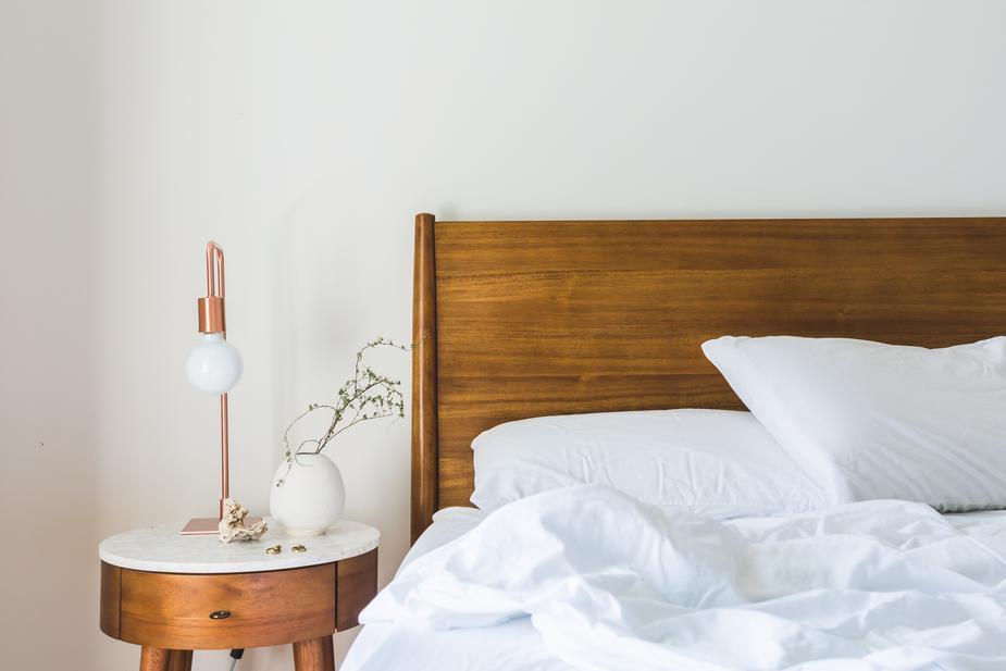 minimalist bedroom with rustic headboard and nightstand and white cotton bedding